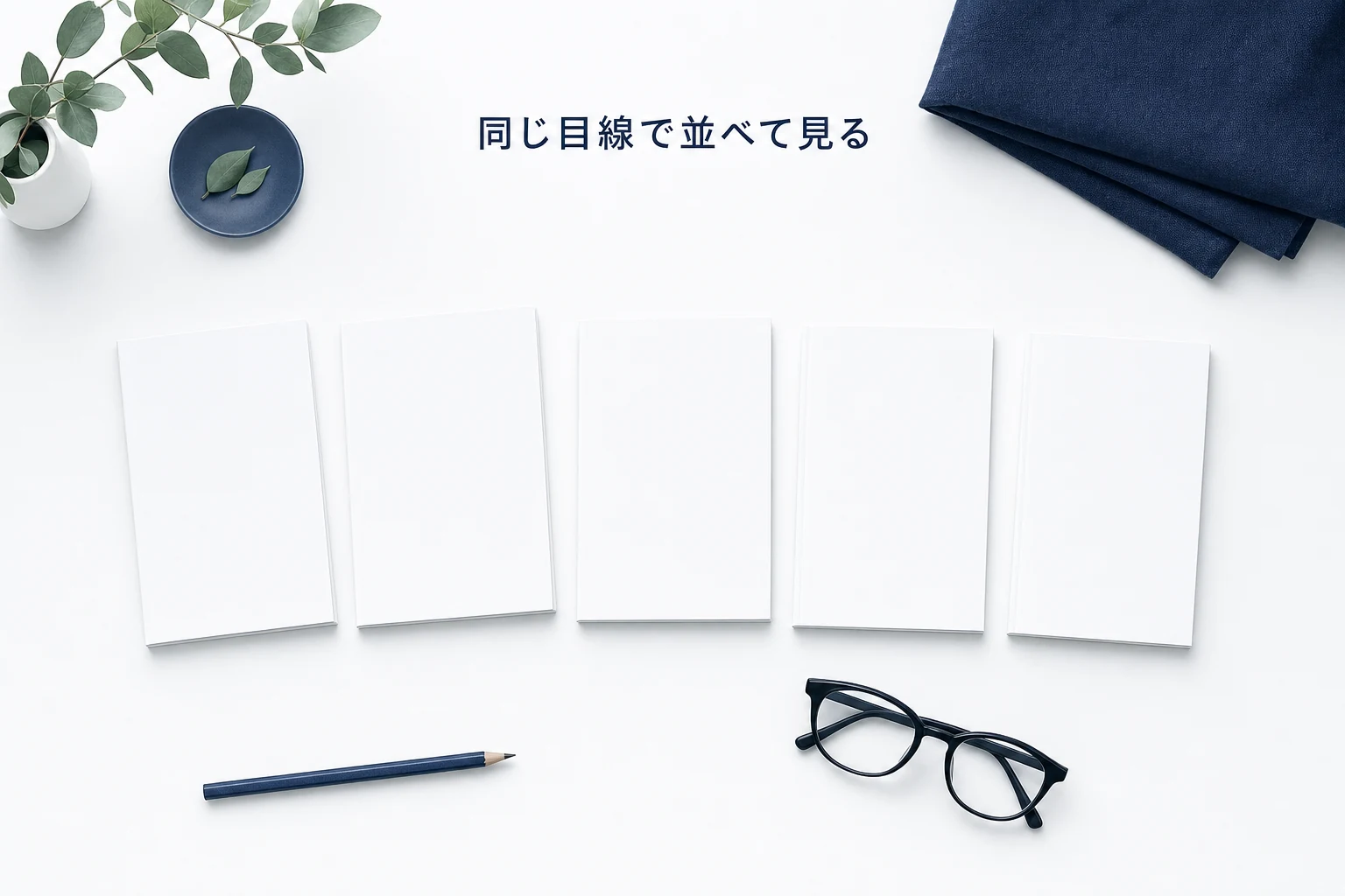 真上から見た机に同じ大きさの白い冊子が五冊、角をずらして横一列に並ぶ見比べのアイキャッチ